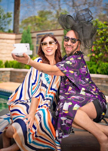 woman and drag queen take a polaroid in caftans